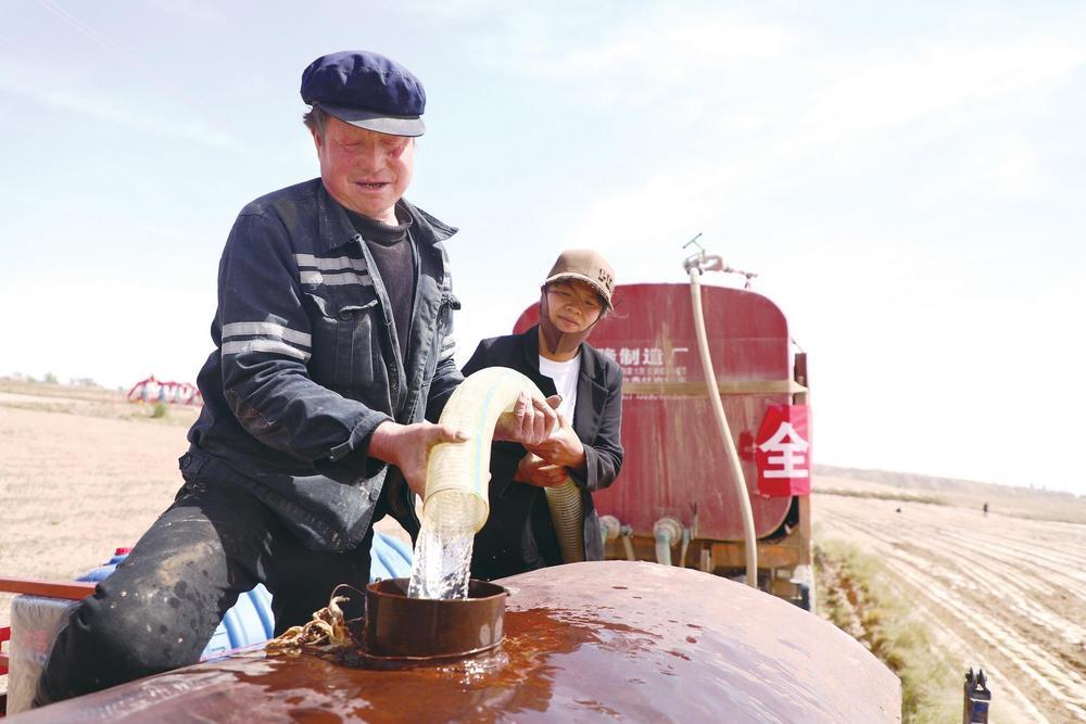 环县罗山川乡大树塬村村民万志娜与父亲一起拉生活用水　新甘肃·甘肃经济日报通讯员　乔洁　摄