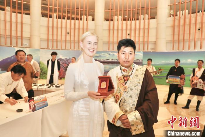4月19日,“圣境甘南—中欧盛宴”暨甘南藏族自治州国际旅游推介活动在陕西西安举办。扎西当知布(右一)受邀参加,其个人绘制的微型唐卡受到外国嘉宾的喜爱。(受访者供图)