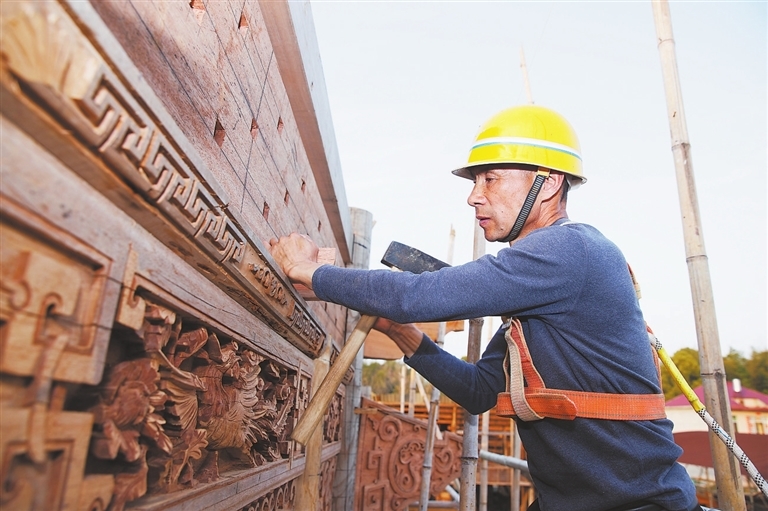 陈乐平拴着安全绳，进行戏台主体框架安装。