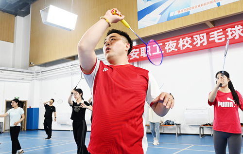 4月25日，雄安新区容西职工文体活动中心内，雄安职工夜校羽毛球班开课，教练王硕（右二）正在指导学员进行羽毛球训练。
