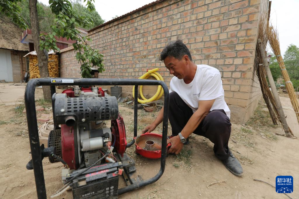 5月21日，在甘肃省定西市通渭县寺子川乡，农民检修抽水设备。新华社发（王克贤　摄）