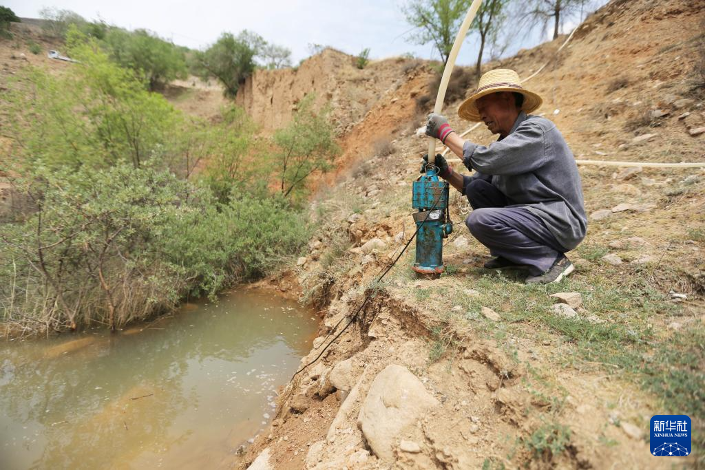 5月21日，在甘肃省定西市通渭县寺子川乡，农民检查水泵准备抽水浇地。新华社发（王克贤　摄）