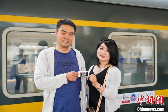 图为旅客在K520次列车前拍照留念。　张佳豪 摄