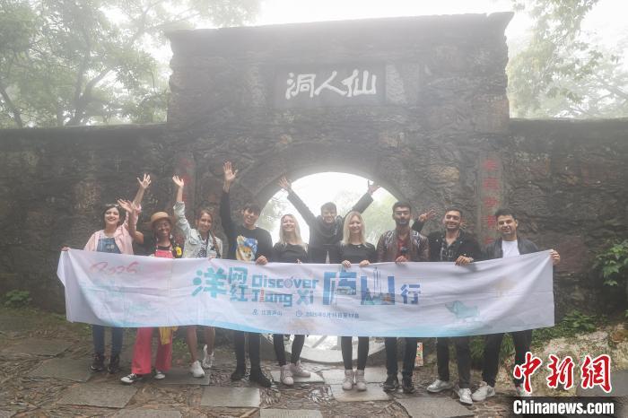 5月16日,江西庐山,多国“洋网红”在仙人洞门口拍照合影。中新社记者 刘力鑫 摄