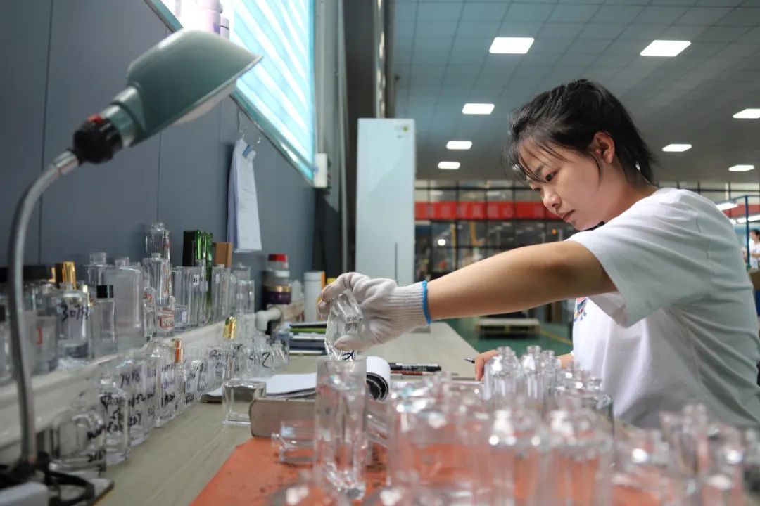 5月20日,甘肃富地金虹玻璃制品有限公司质检车间内,操作人员正在对化妆品瓶进行容量测试。