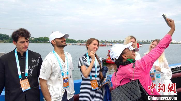 图为5月17日，参加洋网红“Discover　JiangXi”走进八里湖活动的多国“洋网红”在龙舟赛现场拍照。刘占昆 摄