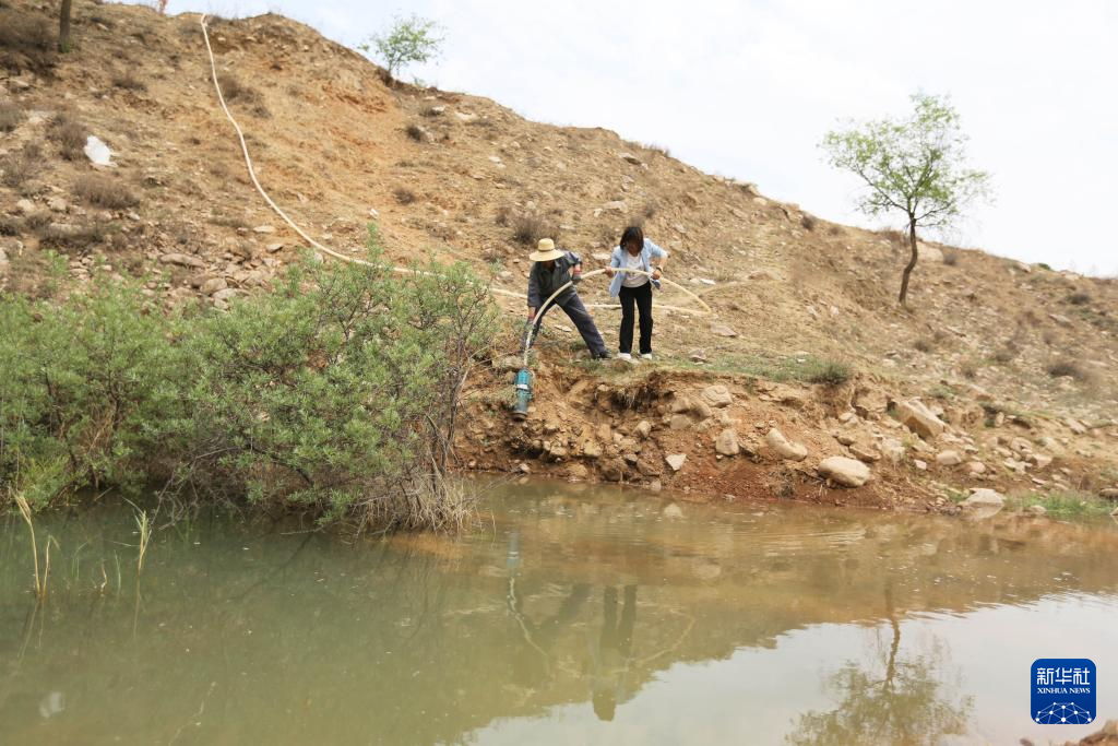 5月21日，在甘肃省定西市通渭县寺子川乡，农民准备抽水浇地。新华社发（王克贤　摄）