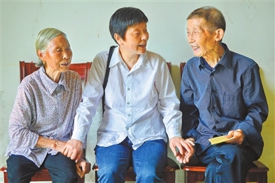 甘公荣（中）走访群众。莲花县委宣传部供图