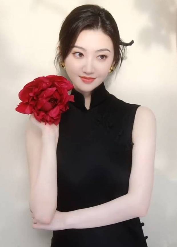 景甜手拿大红花拍照。