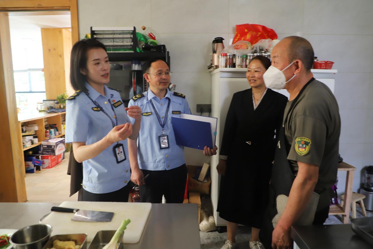 大峡谷所所长李阳(左)和工作人员周大虎(中)检查民宿后厨卫生情况。