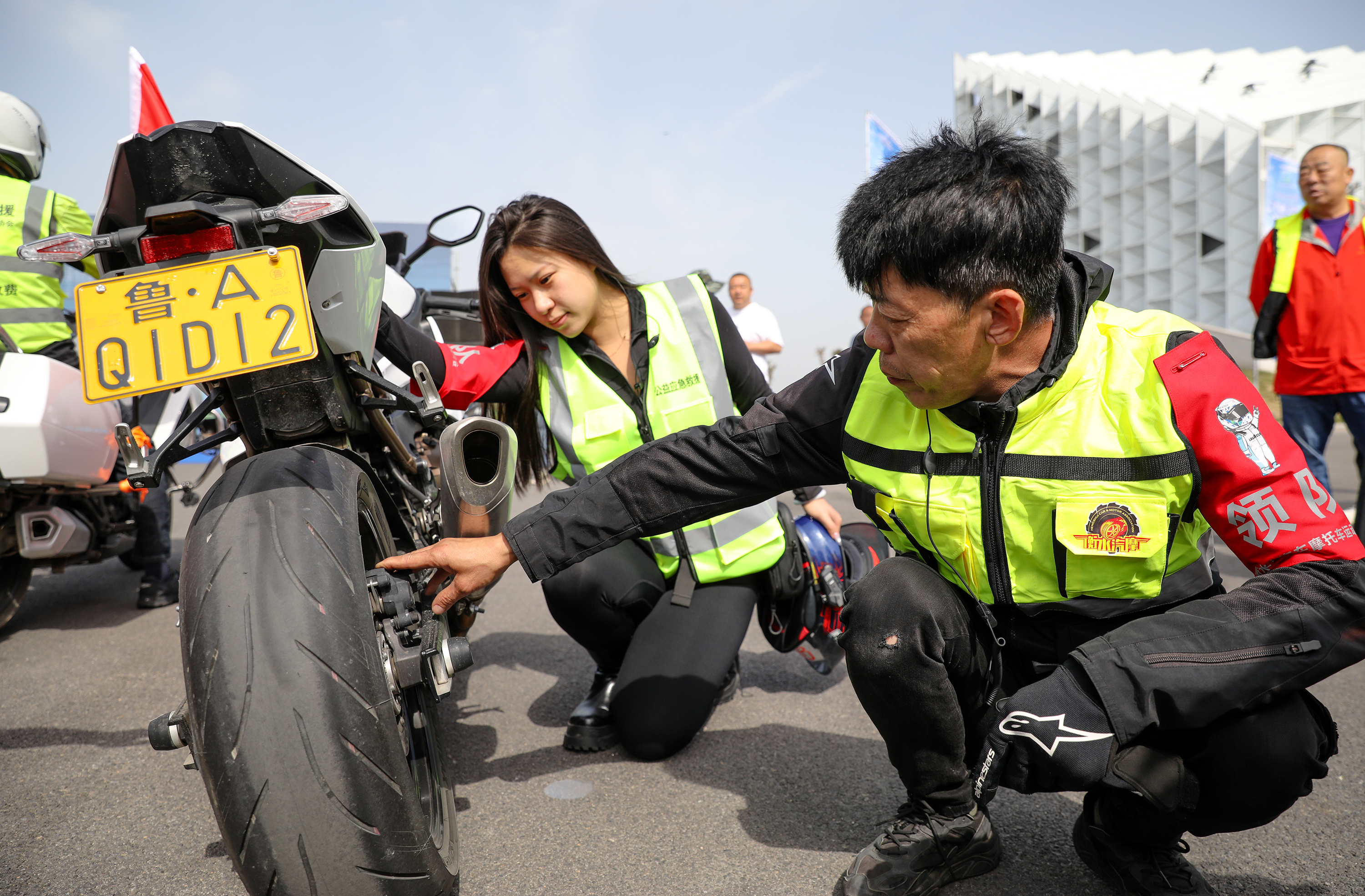 5月18日，骑手正在做骑行前车辆检查。陈康 摄