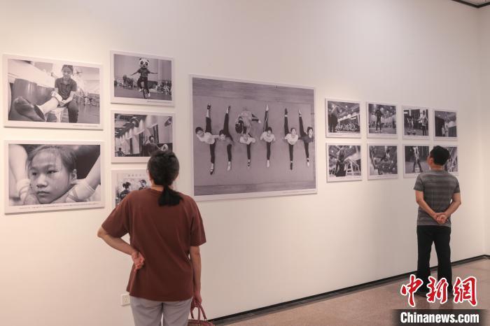图为5月18日,江西南昌,江西省人文纪实摄影十人展现场,观众在观看纪实摄影专题作品《学习·传承·坚守——杂技少年初长成》。刘力鑫 摄