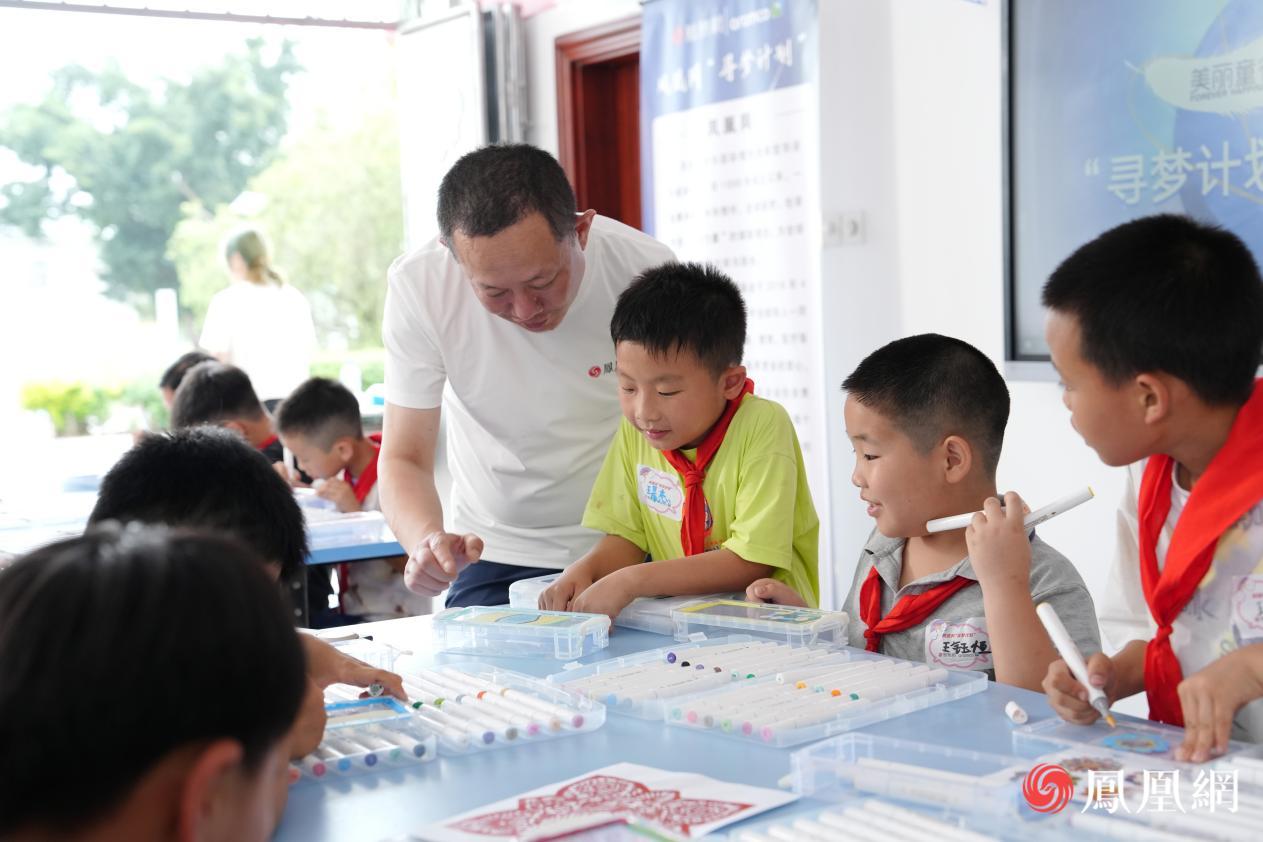 志愿者刘巍老师正在为同学指导色彩运用