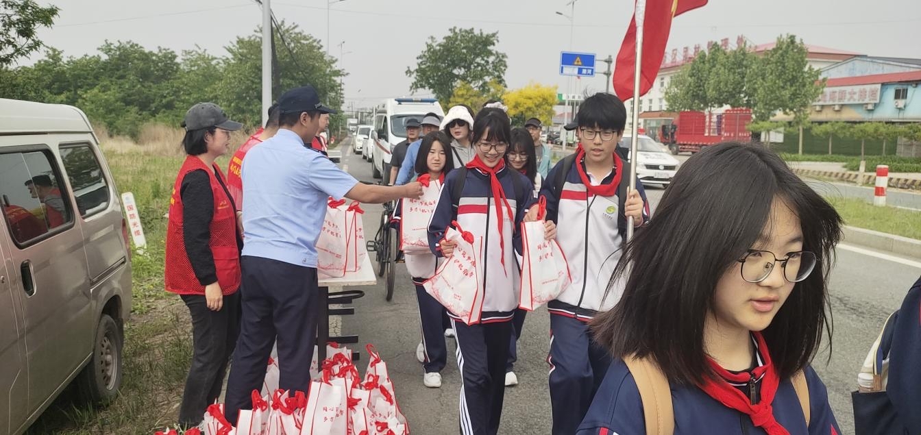 （图为管理处志愿者发放物资 潘璐摄）