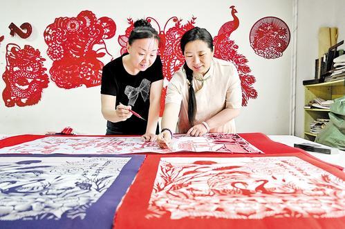 5月8日，衡水滨湖新区剪纸艺人李娜（右）正在创作剪纸作品。 本组图片由本报记者焦磊摄