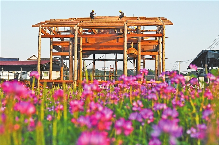 4月2日，乐平市洪岩镇槎源村，由古戏台营造技艺国家级非物质文化遗产代表性传承人陈乐平督造的古戏台，正在田野间“拔节生长”。