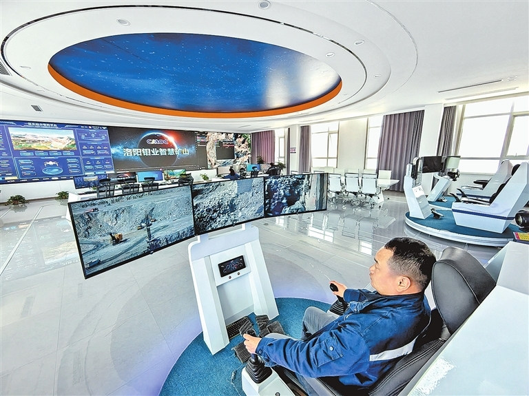 在洛阳钼业智能调度中心，技术人员通过屏幕监控矿区情况，并远程操控挖掘机等进行作业。 张光辉 侯豫炯 摄