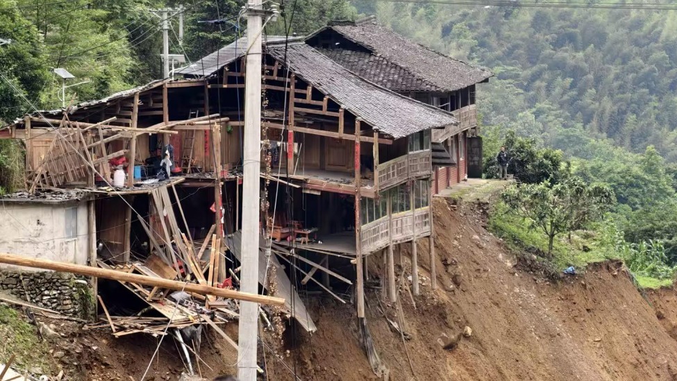 广西龙胜山洪泥石流救援现场：几幢木制房屋地基已基本悬空