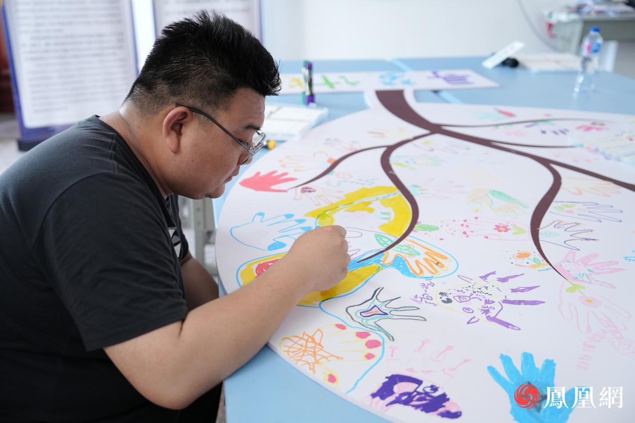 志愿者贾俊栋老师正在为孩子们的“梦想树”进行点缀