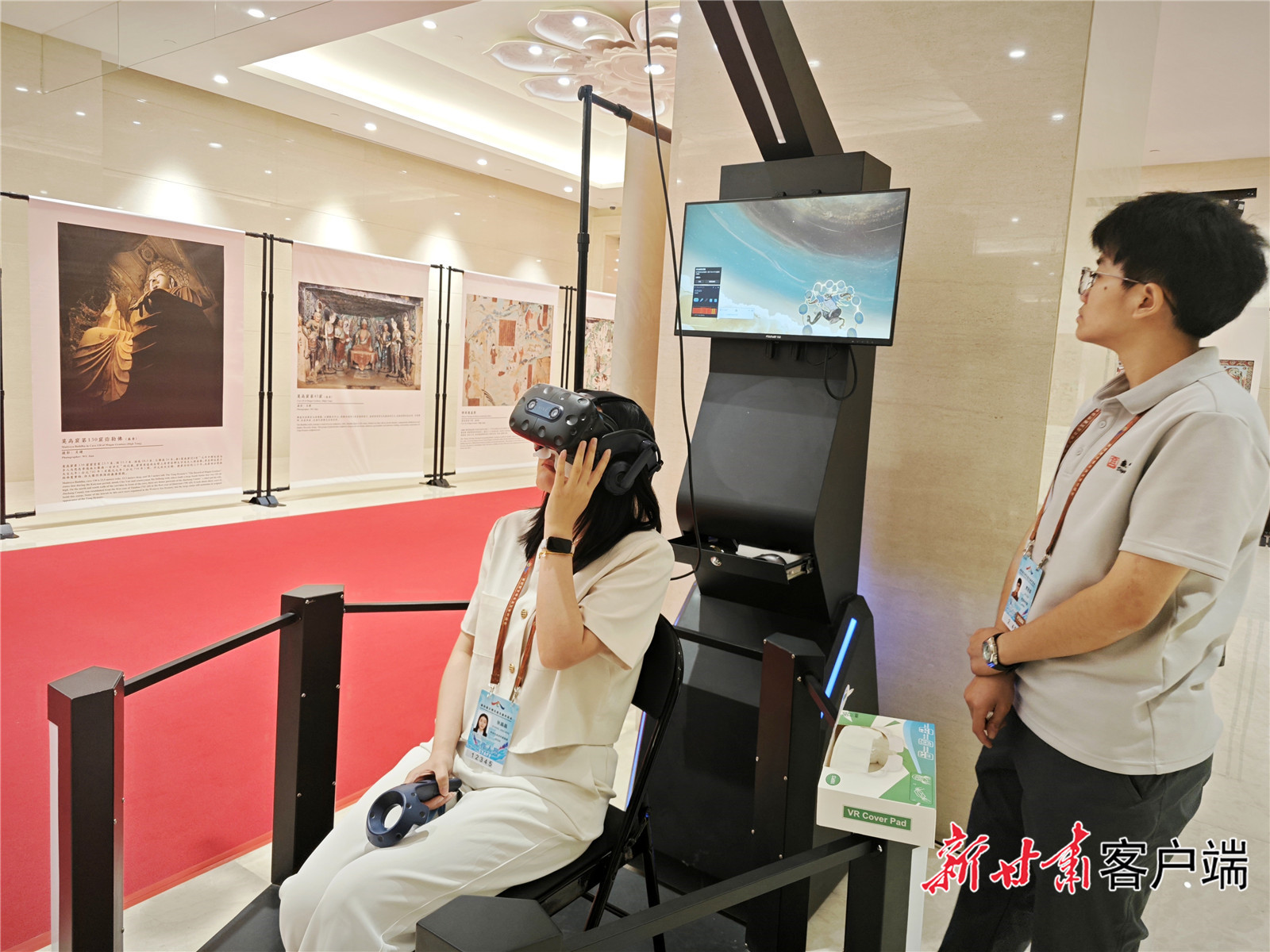 嘉宾戴上VR眼镜，拿起手柄，体验“寻境敦煌”项目。（新甘肃&middot;甘肃日报记者　吴涵）