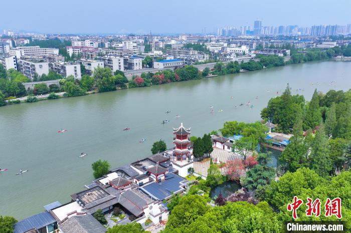 5月24日,2025年湖北省桨板公开赛(襄阳站)在湖北襄阳护城河开赛。湖北省近200名桨板运动健儿及爱好者汇聚襄阳古城,在碧波荡漾间感受生态之美,领略“亚洲最宽护城河” 的魅力。图为运动健儿“逐浪”襄阳护城河。张倩龙 摄