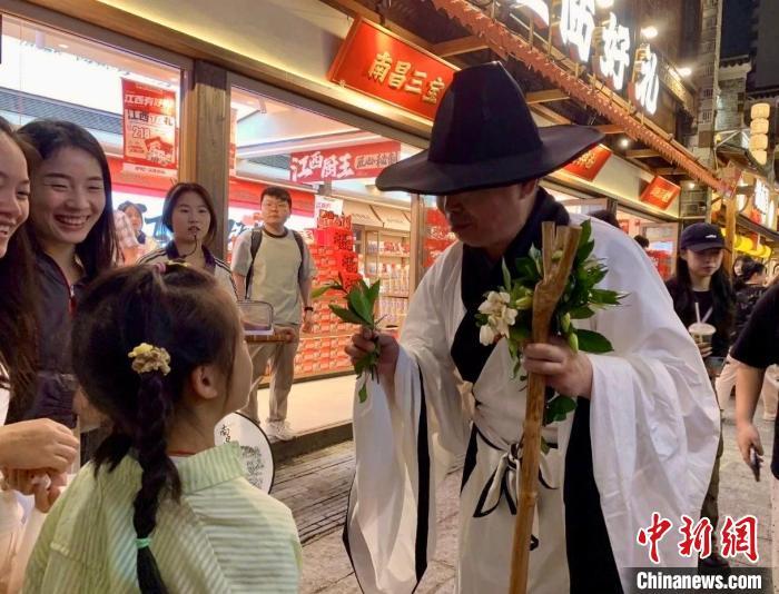 图为在南昌万寿宫历史文化街区,八大山人NPC与游客进行互动送花。 活动主办方供图
