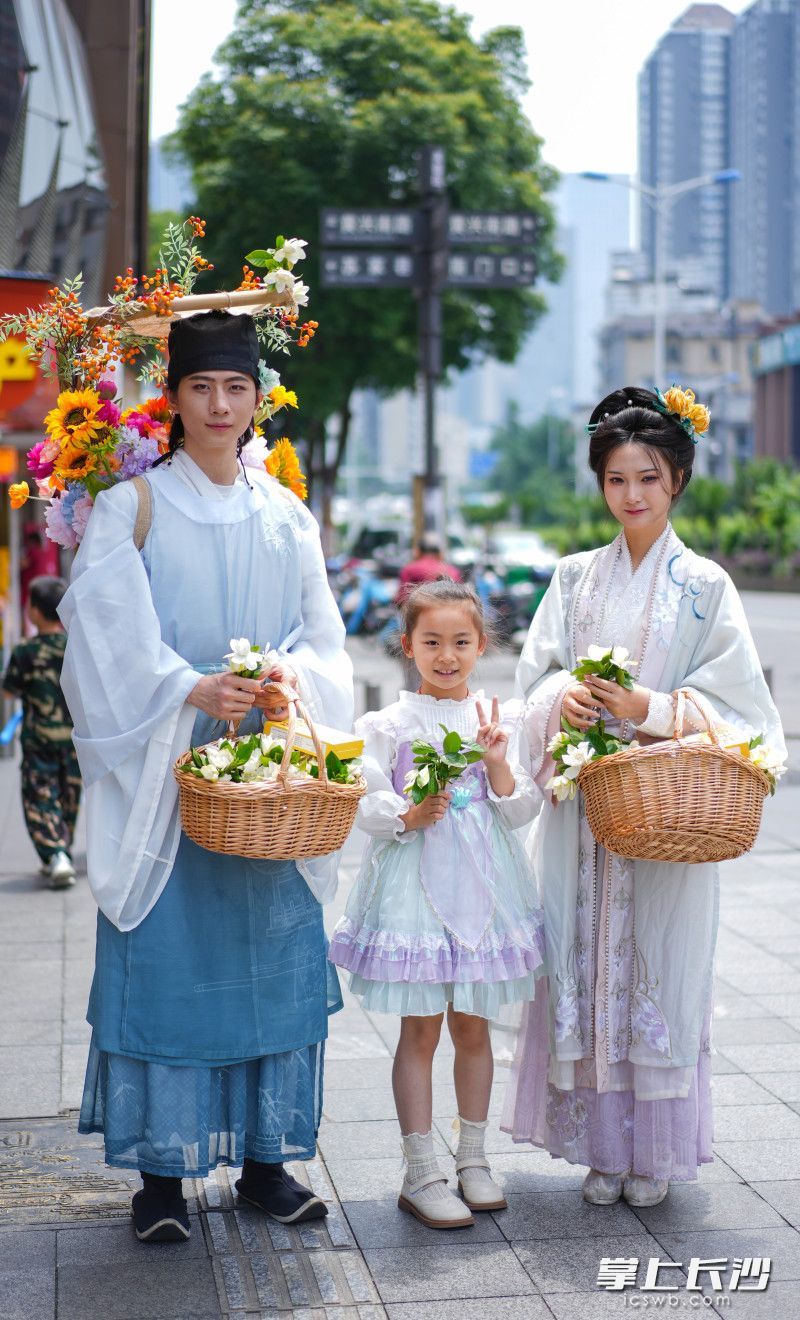 盛装打扮的簪花郎来到黄兴广场给市民送栀子花。