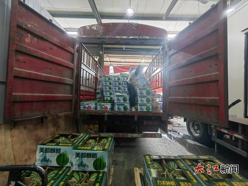 水果批发商将来自河南的西瓜搬运下车。