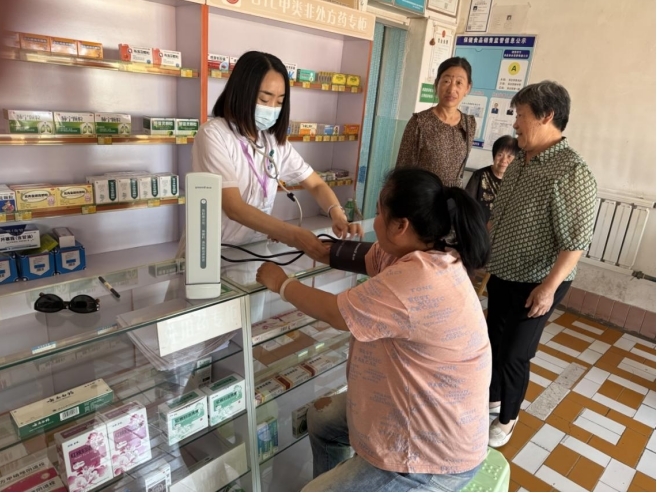 志愿者为村民测量血压。马新月 摄