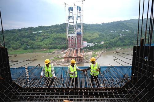 ▲5月28日,渝万高铁石沱长江大桥首个主塔实现封顶,中铁大桥局的技术工人正在高空加紧施工。 记者 罗斌 摄
