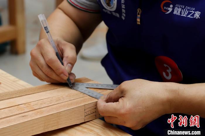 图为正在进行比赛的木工制作能手。中新社记者 熊锦阳 摄
