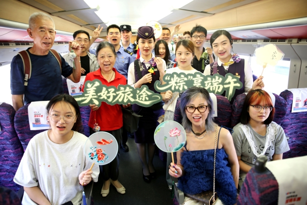 2025年5月29日，在G7583次高铁列车上，乘务员与旅客互动开展迎端午活动。 王春 图