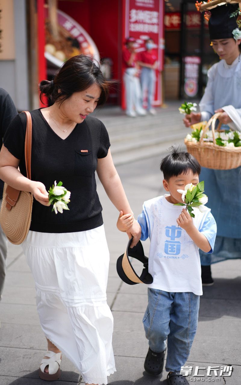 一位小朋友收到簪花郎送的栀子花。