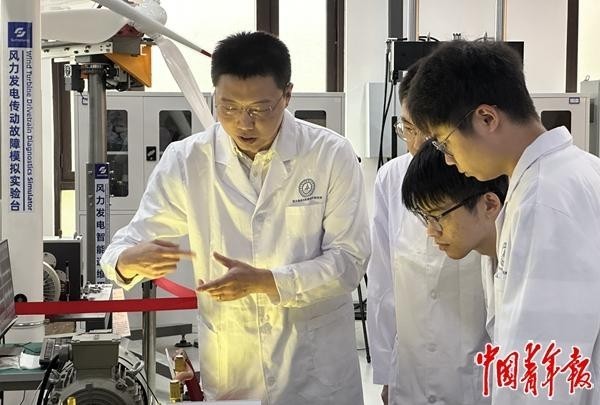 西安交通大学机械工程学院教授李响和博士研究生正在高端装备智能运维实验室交流(左一为李响)。中青报·中青网记者 宋莉/摄