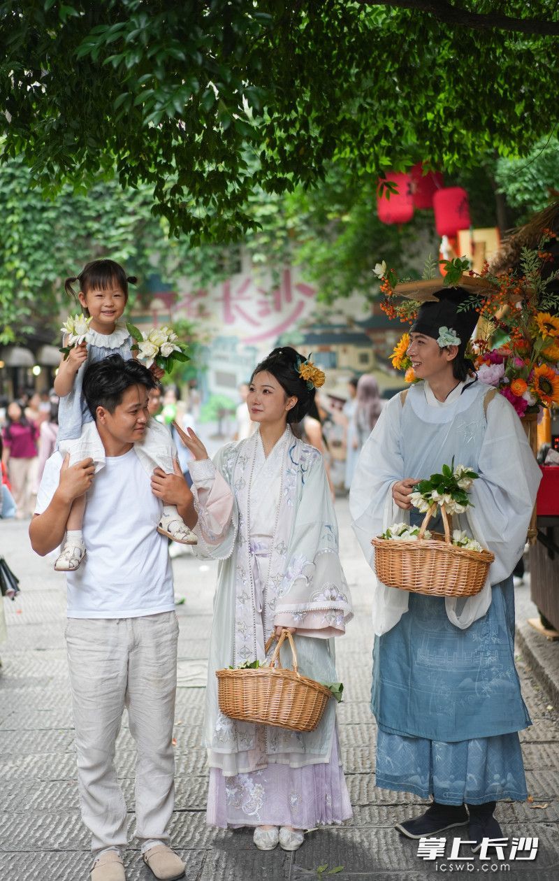 盛装打扮的簪花郎来到丰盈西里给市民送栀子花。均为长沙晚报全媒体记者 邹麟 摄