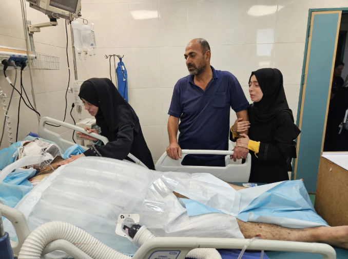 以色列空袭了他们的家后,巴勒斯坦医生阿拉·纳贾尔 (Alaa al-Najjar) 前往加沙汗尤尼斯纳赛尔医院重症监护室探望受伤的丈夫哈姆迪