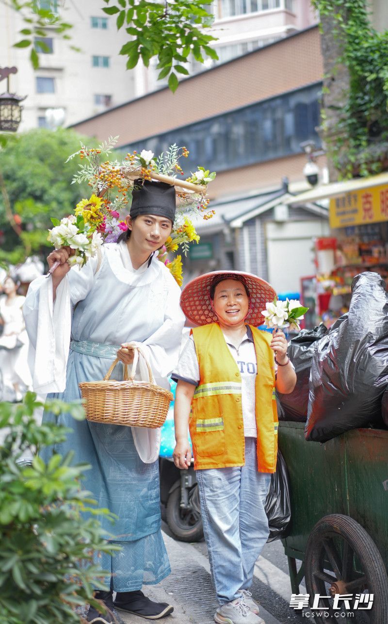 盛装打扮的簪花郎走上长沙街头给环卫工人送栀子花。