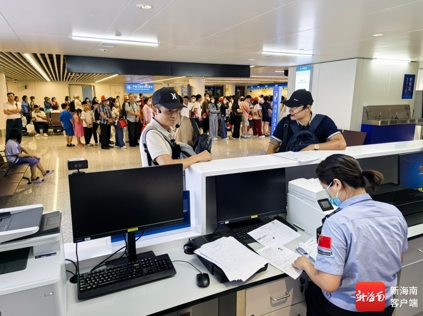 旅客排队通关，边检民警帮忙办理手续。边检供图