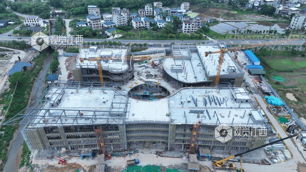 2025年6月5日,江西省遂川县文化产业中心项目施工进入竣工冲刺阶段,建筑工人正利用晴好天气抓紧幕墙等分项工程的建设。