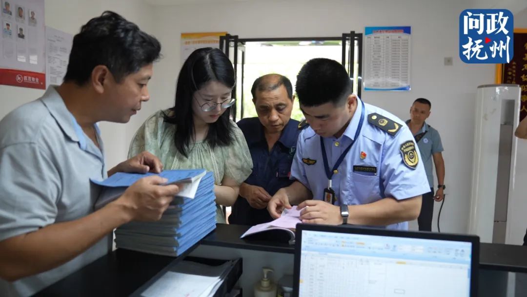 ▲执法人员对小区电梯的维保记录进行查看