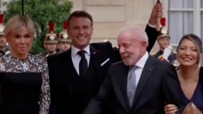 马克龙雨中迎接卢拉夫妇，一人举着两把伞