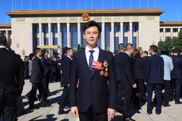 “全国先进工作者”杨俊在人民大会堂前留影。