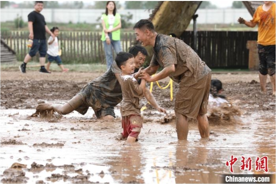 稻田寻宝、牧场奇遇、插秧比赛……端午节当天，在河北省沧县兴济镇南堤村盐碱稻田乐园里，200多个家庭参与“盐碱稻田寻宝季”活动，感受别样端午。图为游客在河北省沧县兴济镇南堤村的盐碱稻田乐园中体验泥巴作战。 田博 摄