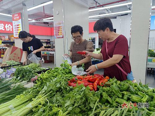 姚小妹(右一)在商业街的超市选购蔬菜。
