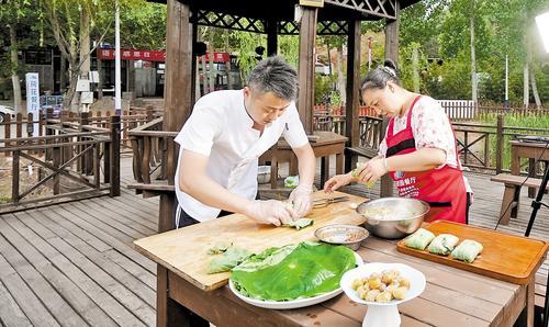 5月31日一大早,在邢台市信都区羊范镇北唐村语荷餐厅,工作人员正在用焯水的荷叶包粽子。 本报记者 吕若汐摄