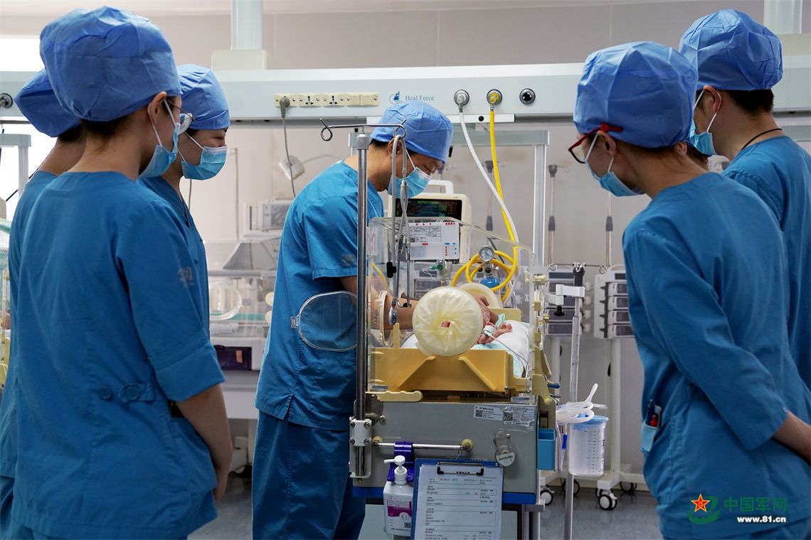 新生儿科医护人员在保温箱前观察新生儿状态。中国军网记者孙悦 摄
