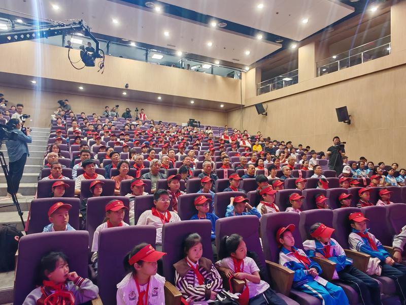图为100名青少年与现场观众整齐落座，全神贯注观看同龄伙伴的精彩演出。