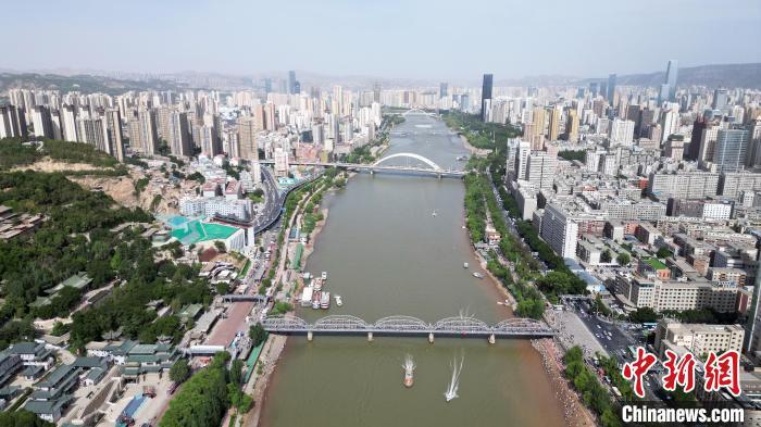 5月31日，甘肃兰州，民众乘坐快艇游览黄河。端午假期首日，众多游客选择在黄河兰州段的茶摊喝茶，乘坐羊皮筏子、快艇游览黄河。（无人机照片）中新社记者　九美旦增　摄