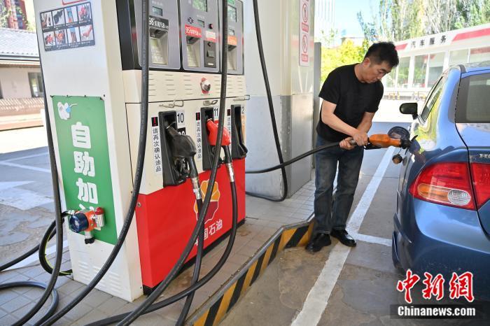 6月3日，内蒙古自治区呼和浩特市，一位男士为汽车加油。当日，中国国家发改委发布消息称，3日24时起，国内汽、柴油价格（标准品）每吨分别上涨65元（人民币，下同）和60元。中国国内油价迎年内第4次上调。 中新社记者 刘文华 摄