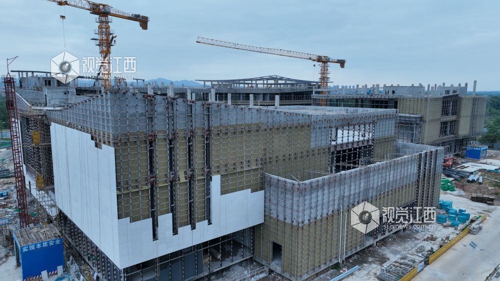 2025年6月5日,江西省遂川县文化产业中心项目施工进入竣工冲刺阶段,建筑工人正利用晴好天气抓紧幕墙等分项工程的建设。
